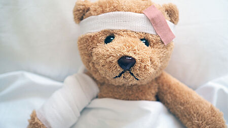 Verletzter Teddy im Bett