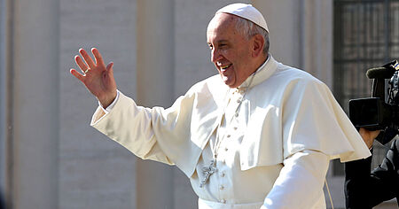 Papst winkt lachend, bei stehender Fahrt durch die Menge