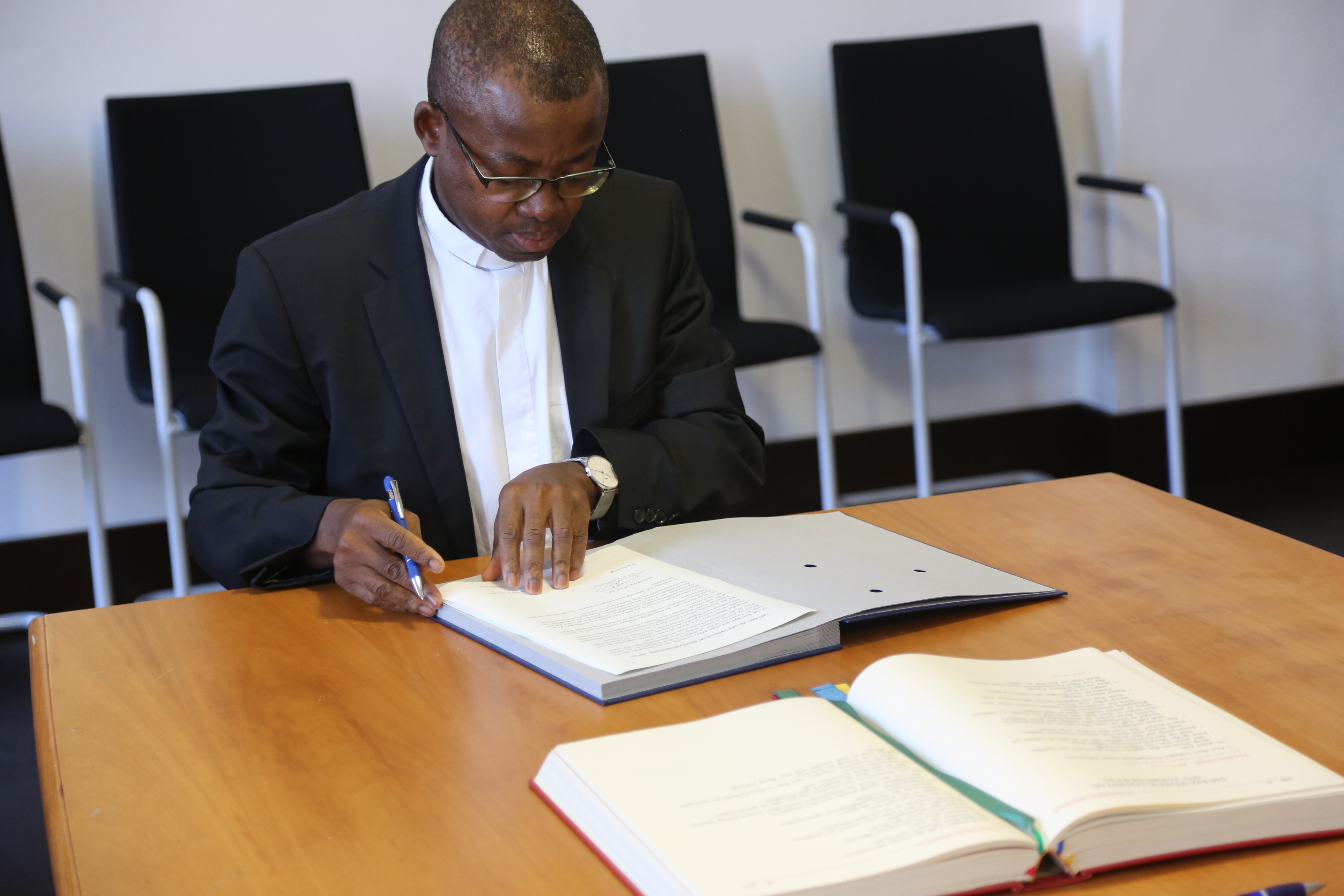 Prof. Dr. Yves Kingata Nkiel Abar unterschreibt, dass er treu zum Glaubensbekenntnis und der Lehre der Kirche steht.