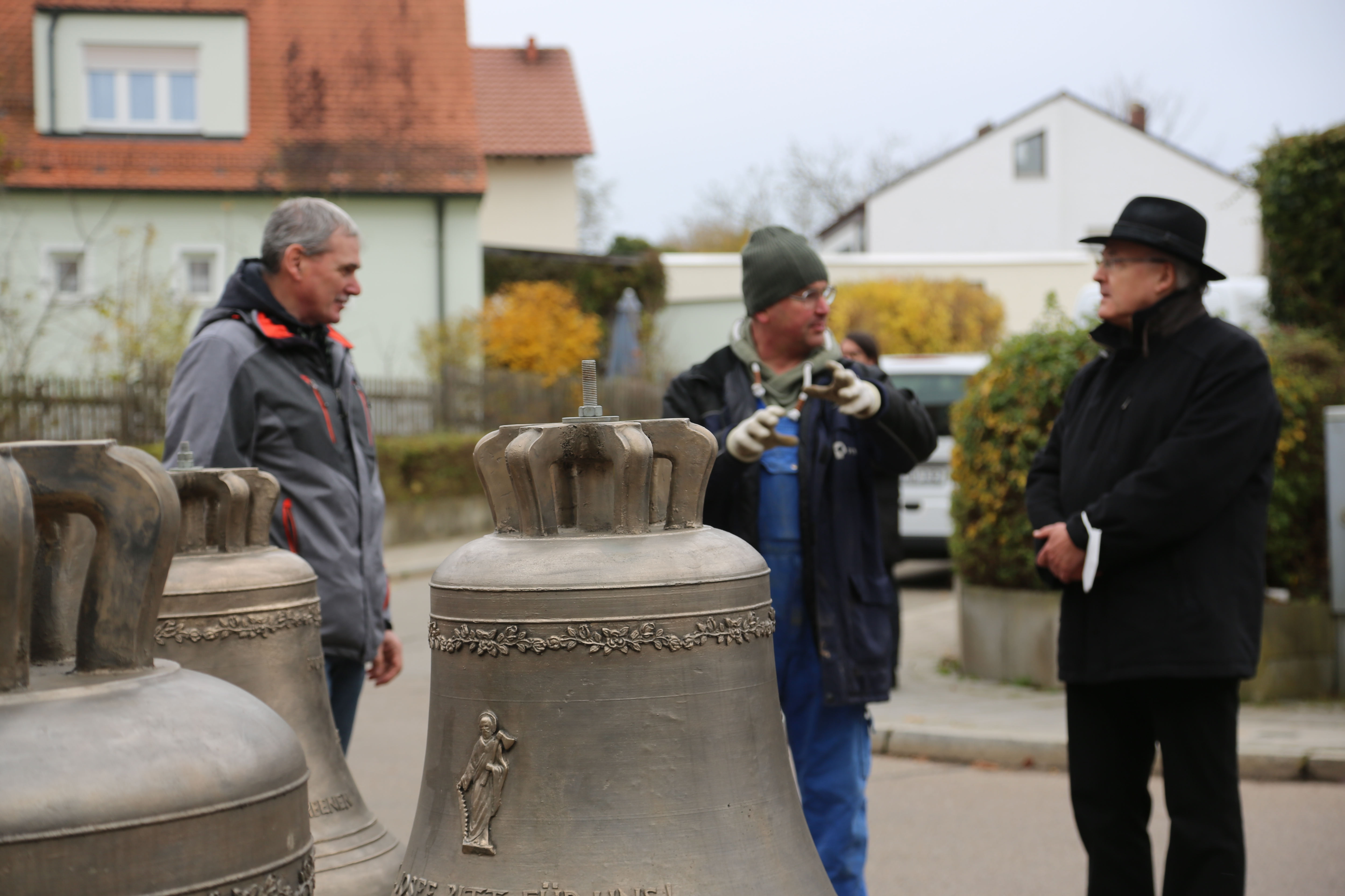 Glockengießer Rudolf Perner erklärt Bischof Rudolf und Kirchenpfleger Erich Tahedl, wie die neuen Glocken im Kirchturm angebracht werden.