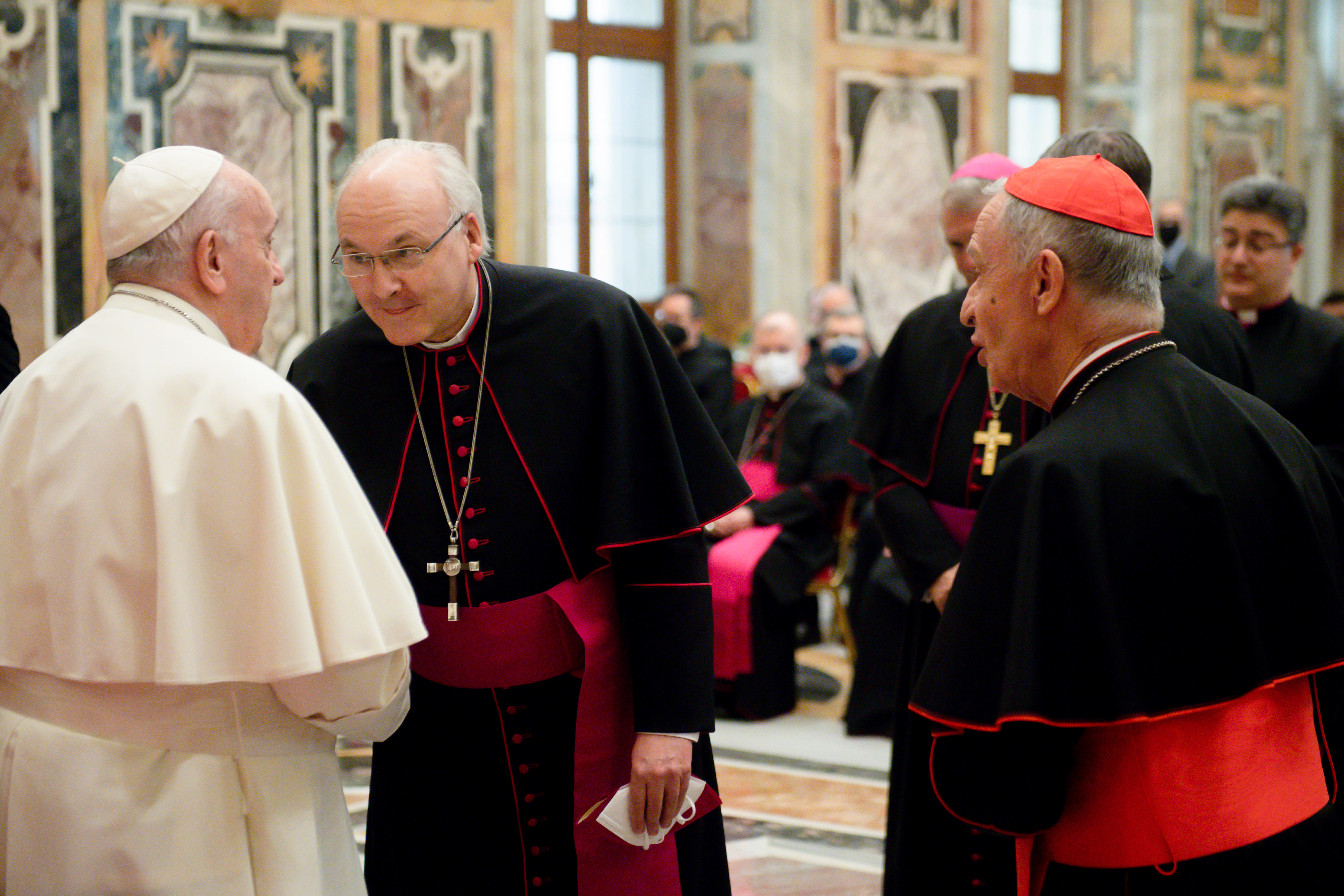 Bischof Voderholzer begrüßt den Papst, außenrum stehen weitere Bischöfe.