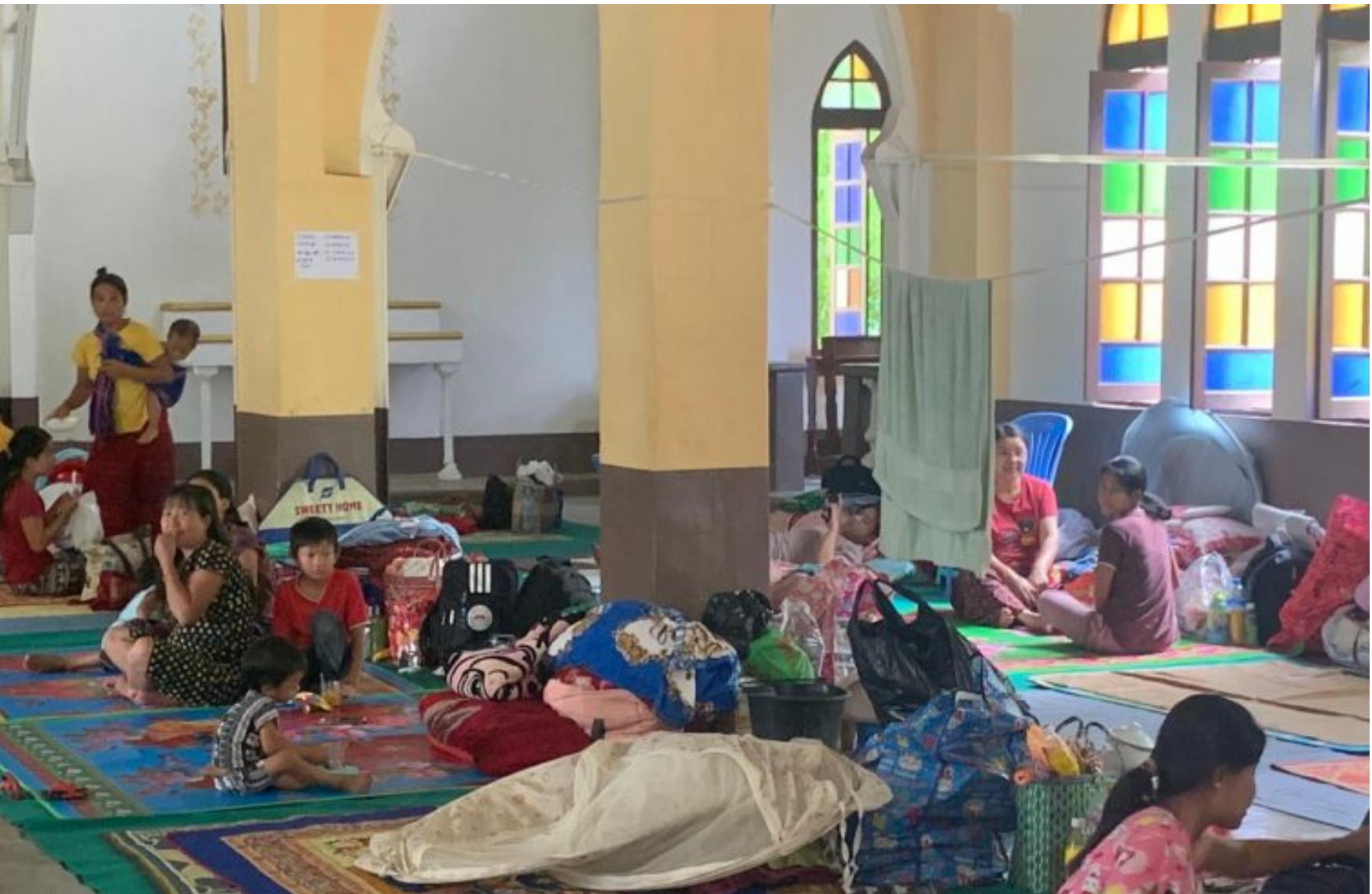 Flüchtlinge stehen und liegen in der Kathedrale auf provisorischen Betten.