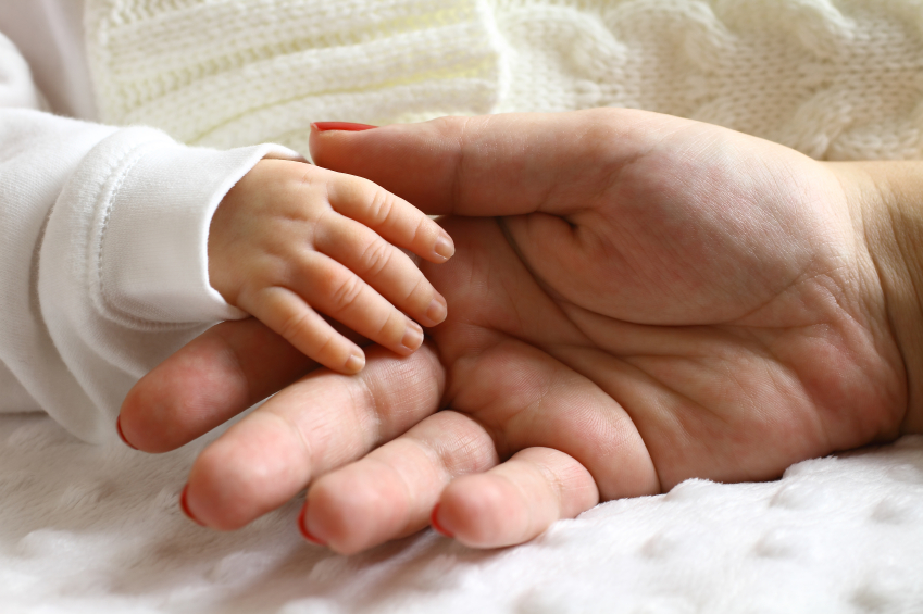 Hand eines Kindes und der Mutter© iStock.com/barisonal