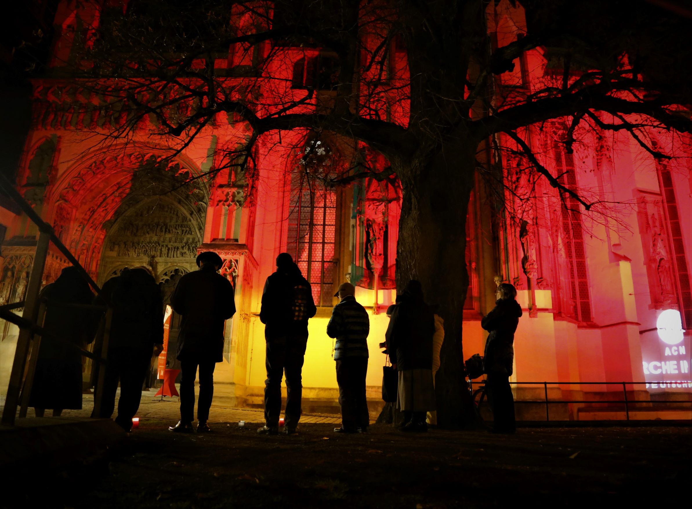 Gebetswache vor dem rot beleuchteten Augsburger Dom © Kirche in Not