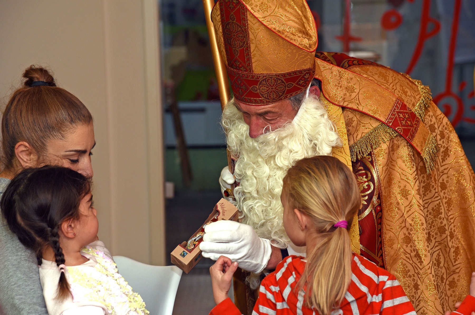 Nikolaus verteilt Schokonikoläuse an Kinder