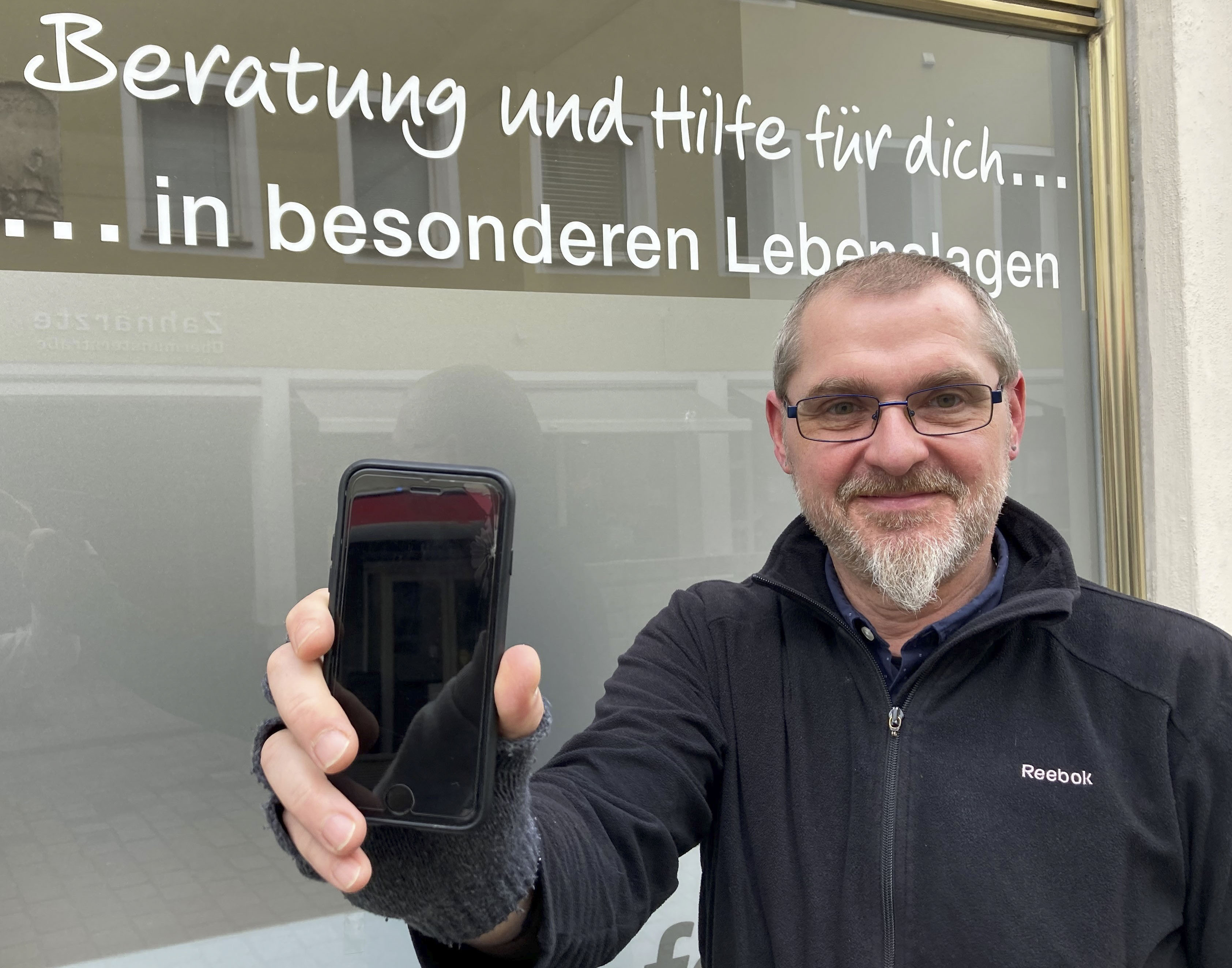 Christian Hierold, Caritas-Fachreferent für besondere Lebenslagen, nimmt gebrauchte Smartphones entgegen und gibt sie an Obdachlose weiter. Foto: Schophoff/Caritas Regensburg