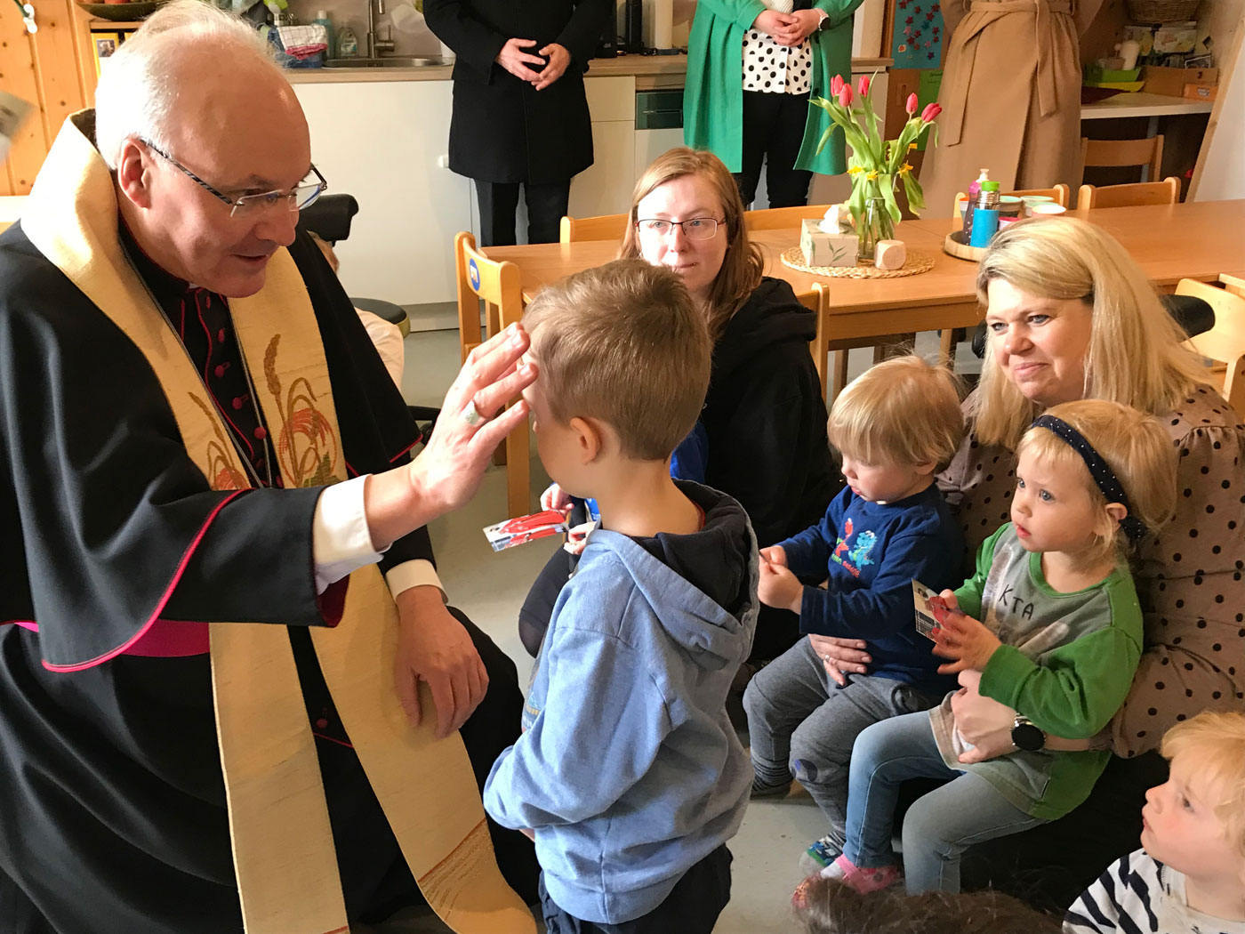 Bischof Rudolf segnet ein Kind