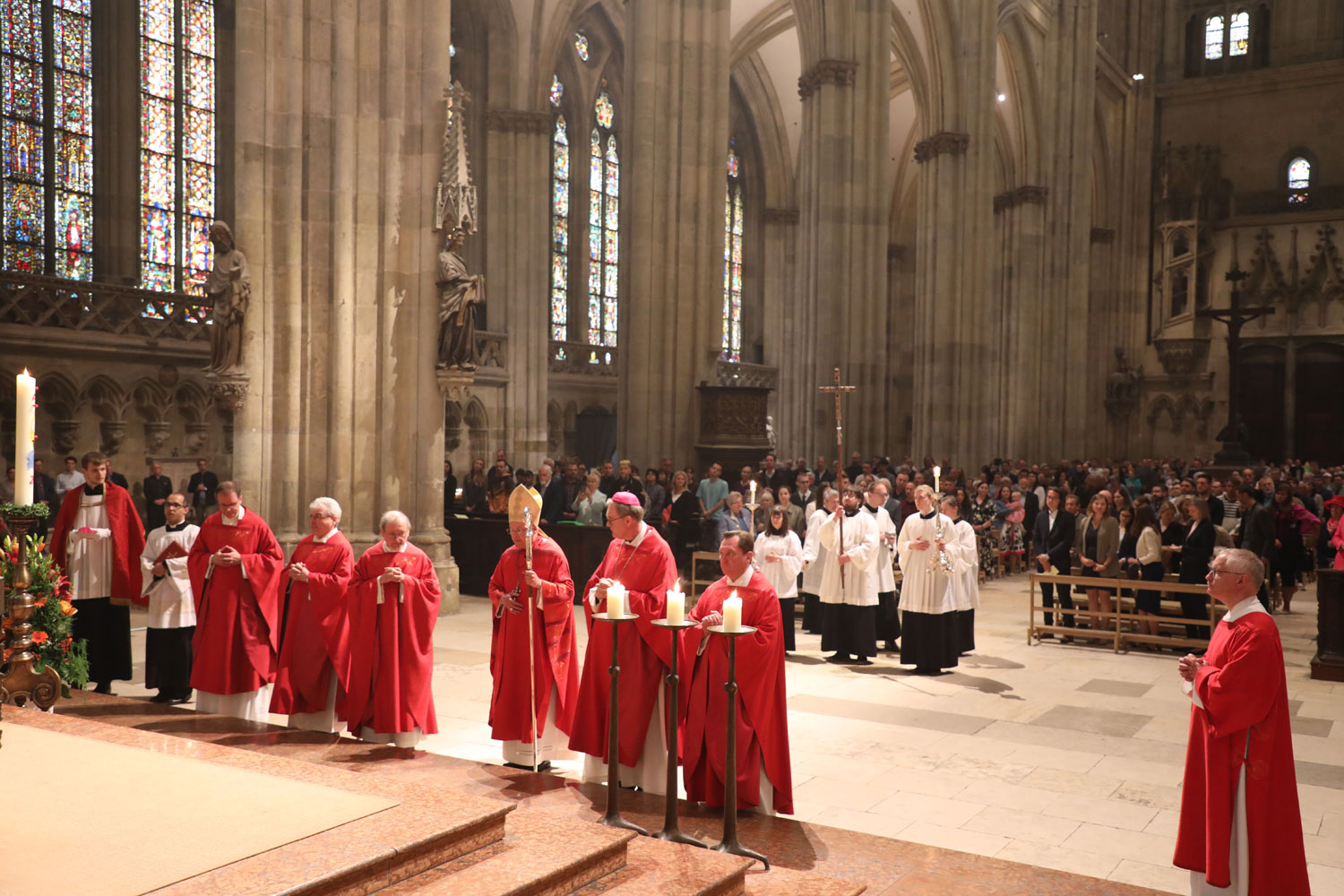 Bischof mit liturgischem Dienst im mit Gläubigen gefüllten Dom