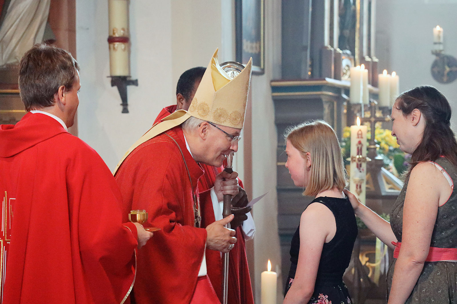 Bischof Voderholzer spricht mit Mädchen vor ihrer Firmung