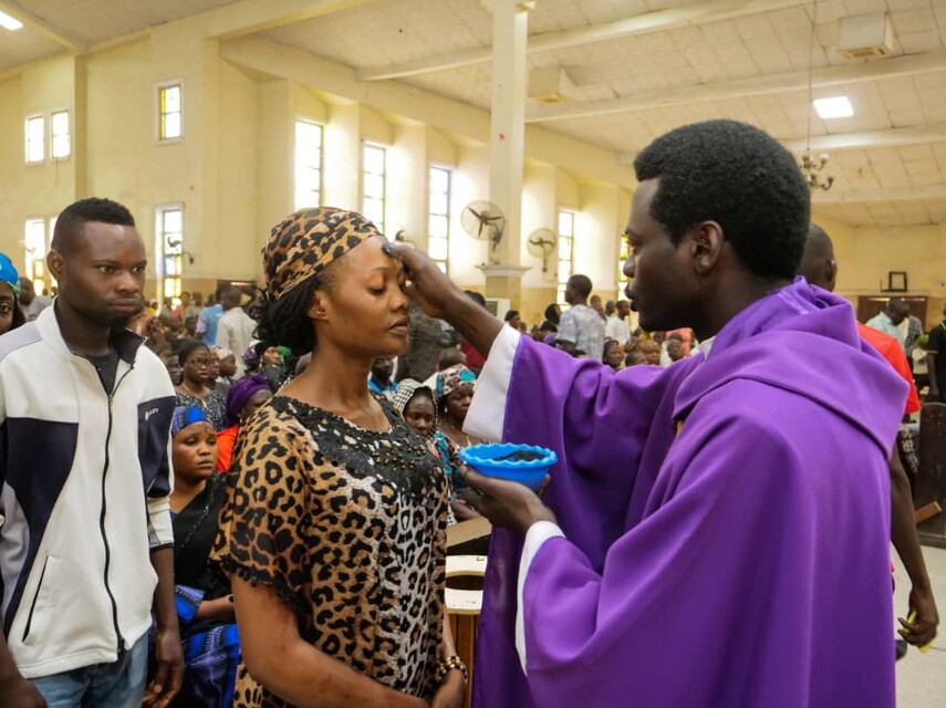 Katholischer Gottesdienst in Nigeria. Frau empfängt Segen. 