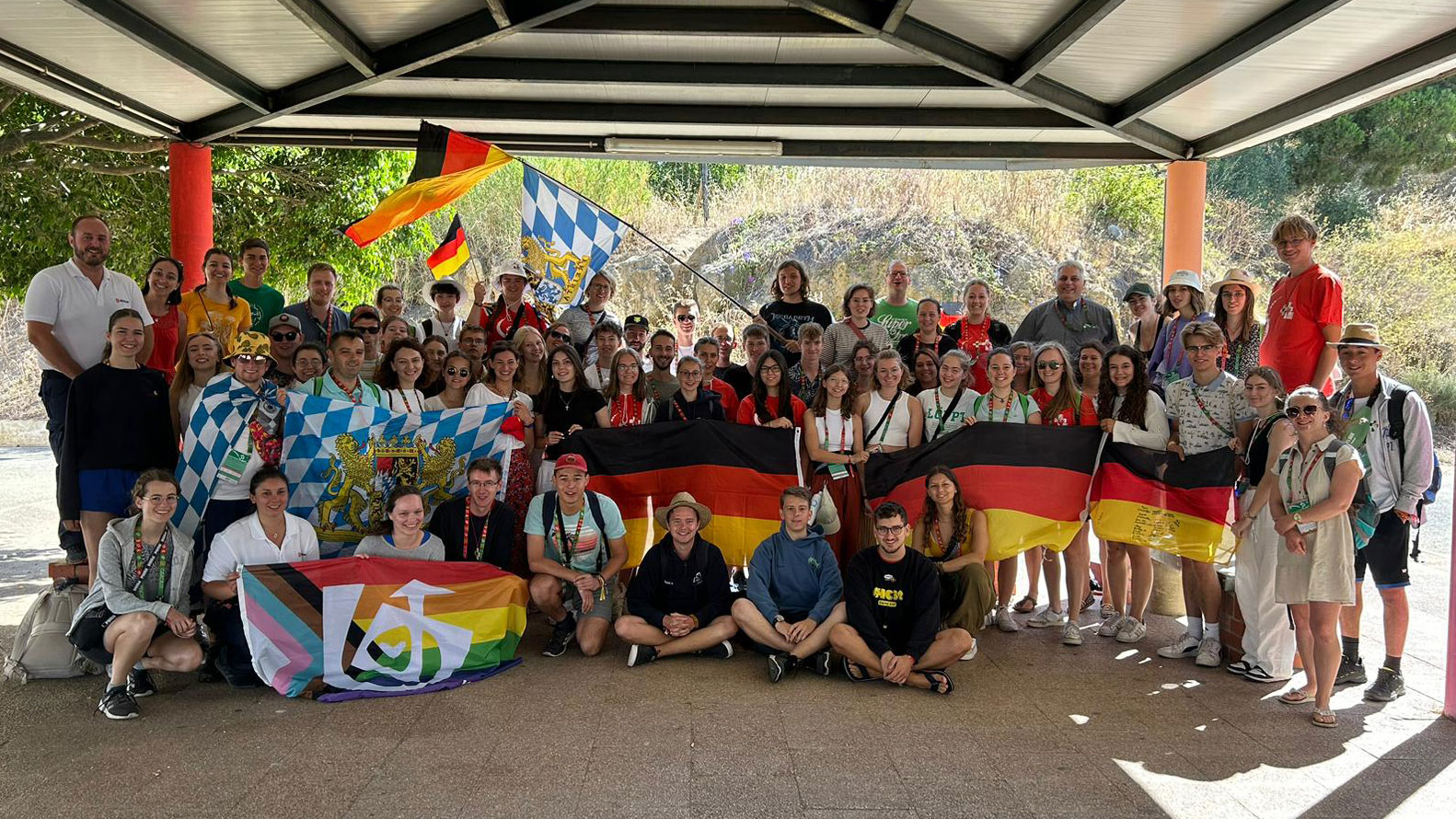 Gruppenfoto von Jugendlichen beim Weltjugendtag, die stolz ihre Flaggen präsentiert