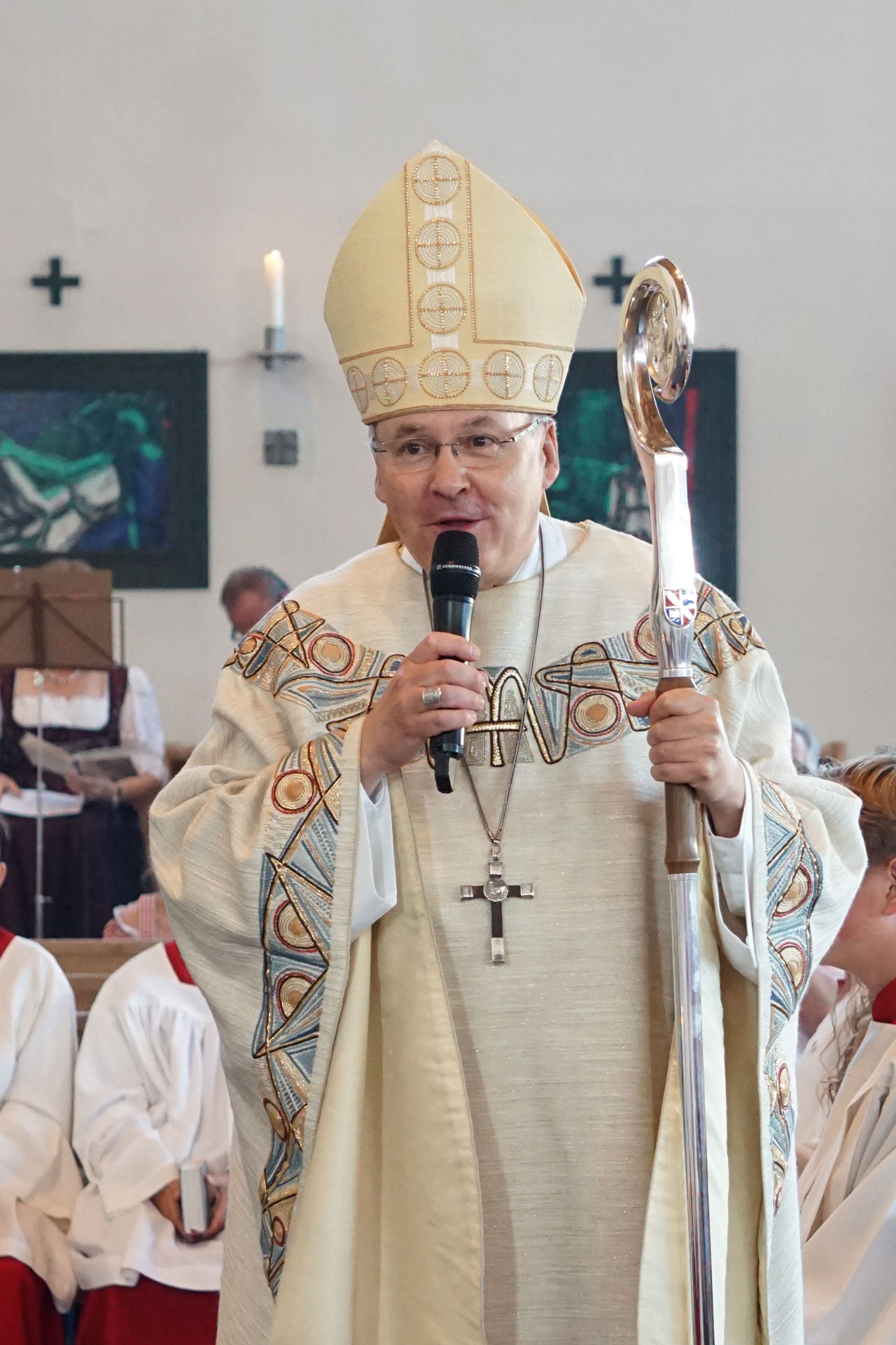 Bischof predigt ins Handmikro