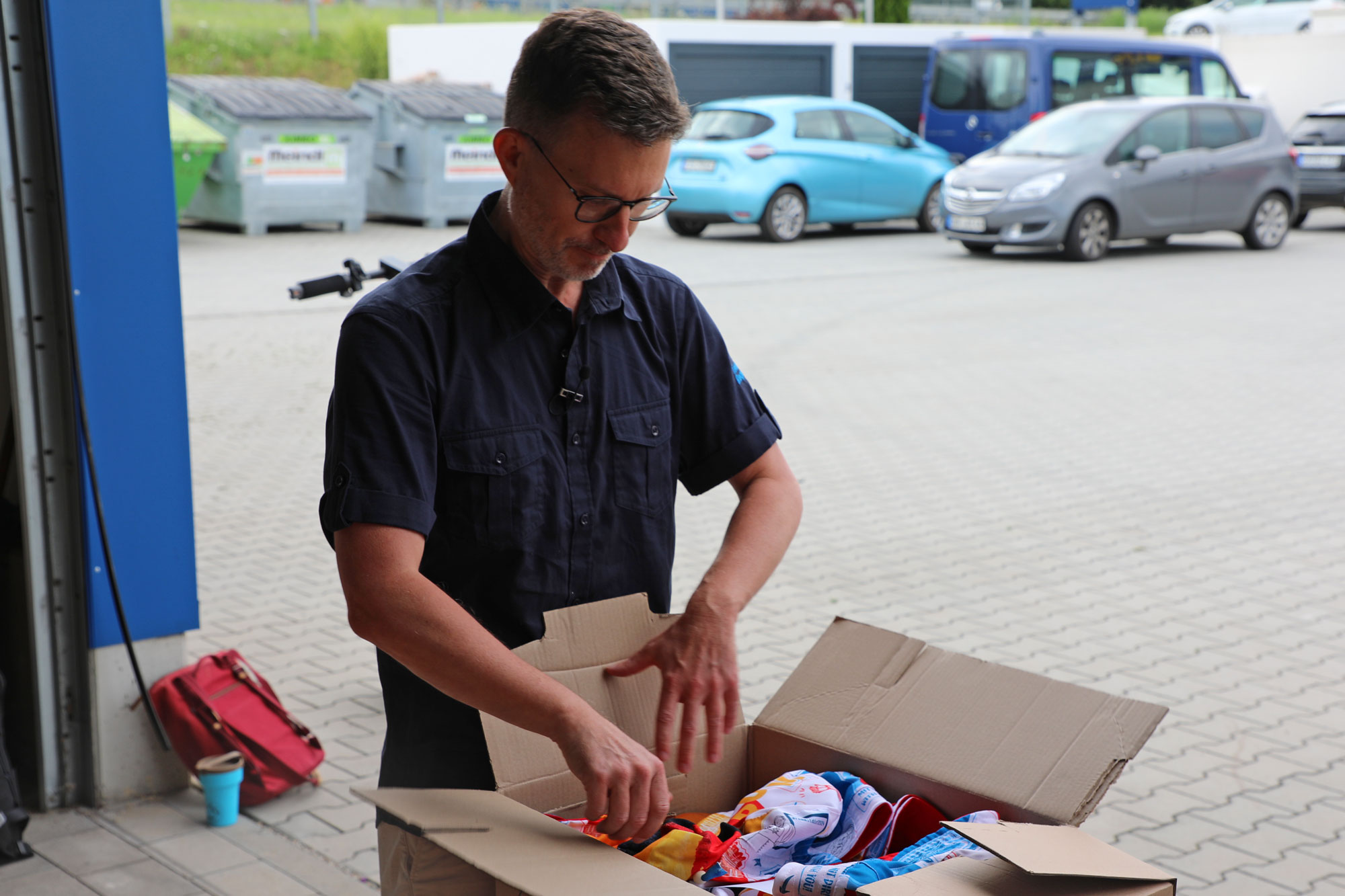 Winfried Brandmeier öffnet eine bereits fertig gepackte Kiste, um den Inhalt zu präsentieren.