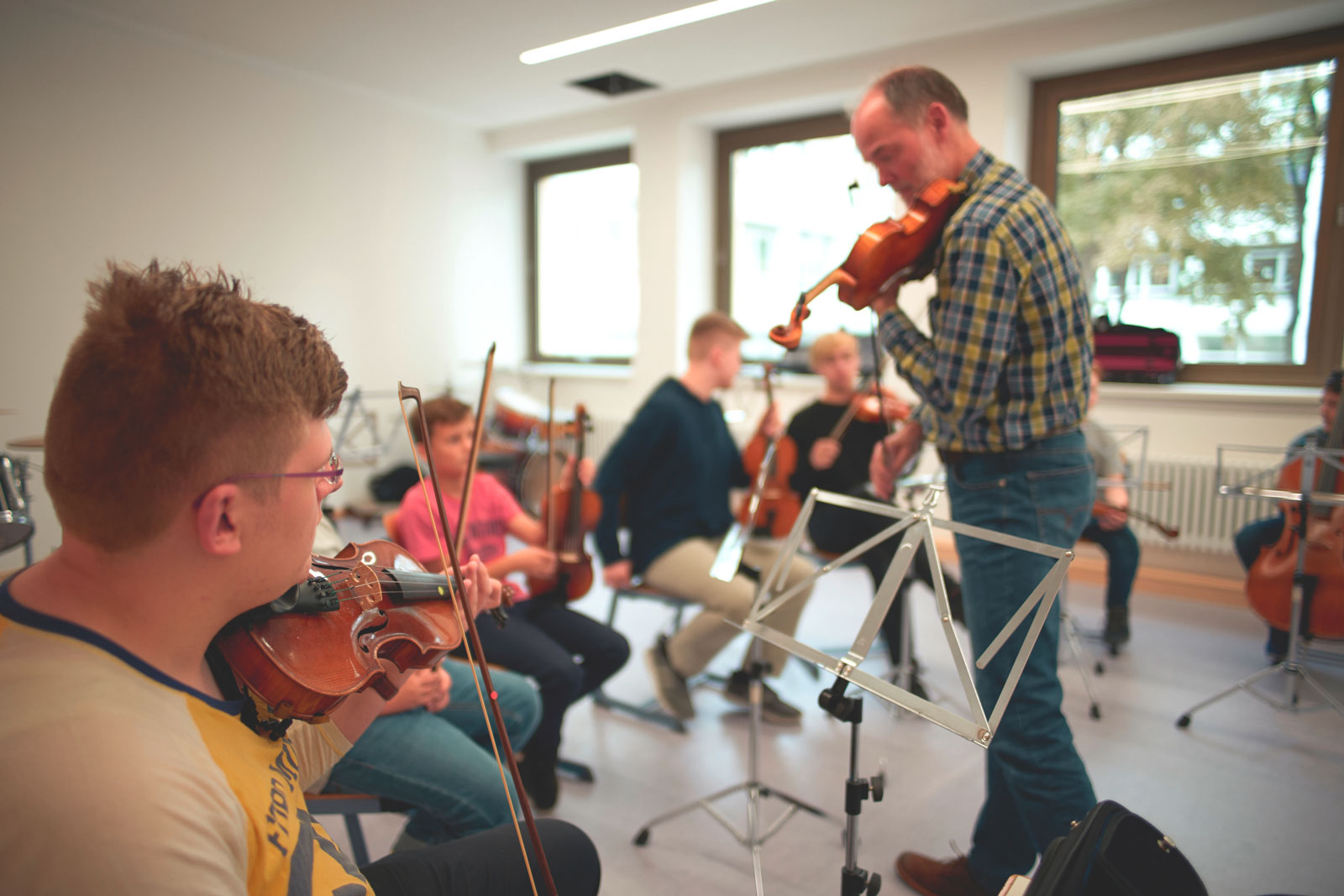 Schüler beim Musikunterricht lernen Geige spielen