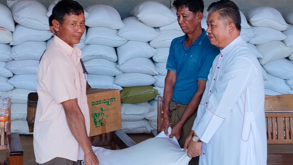 Menschen in Myanmar tragen Reissäcke