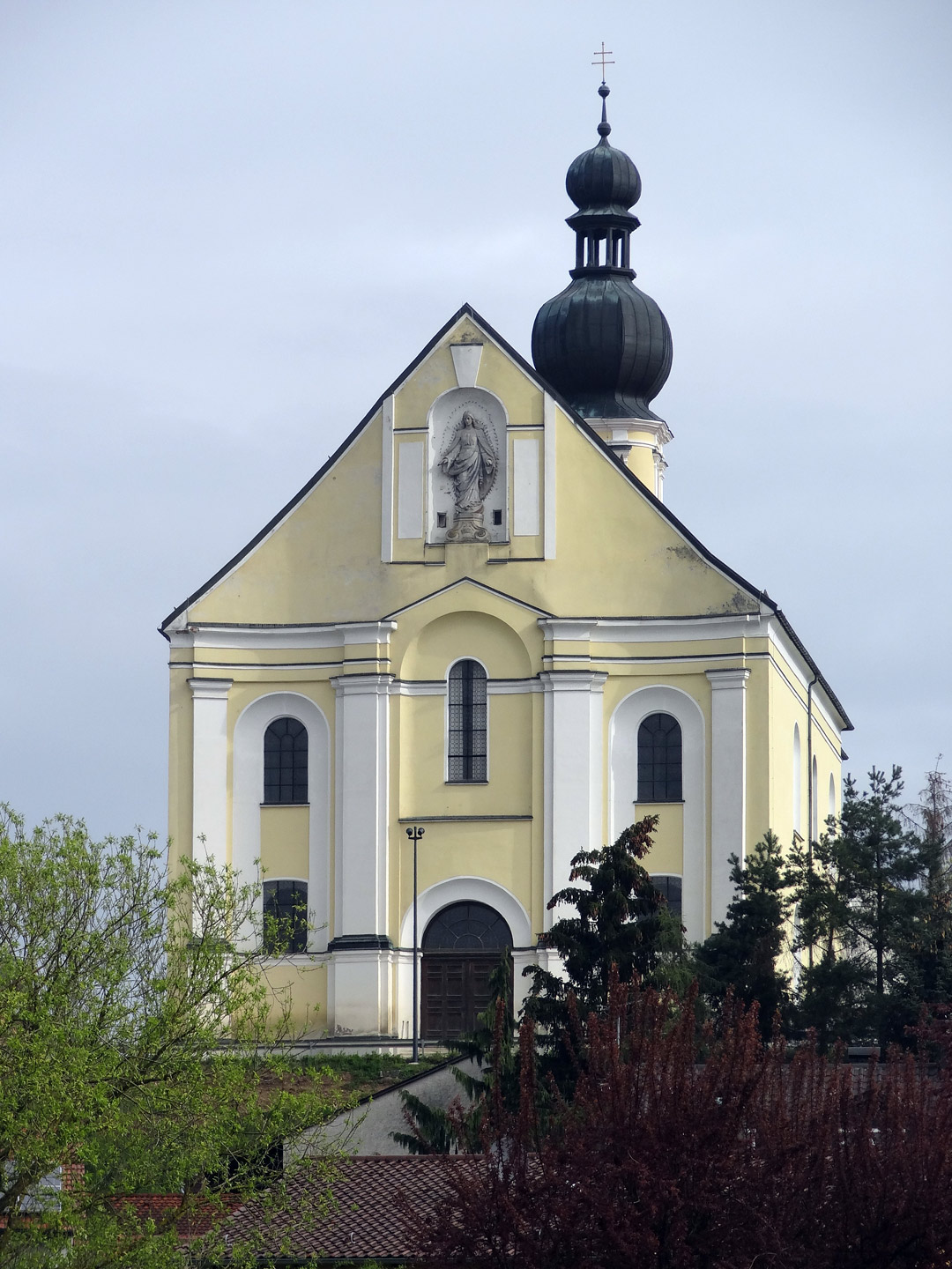 Kurvierte Südfassade der Wallfahrtskirche, Bäume und Himmel