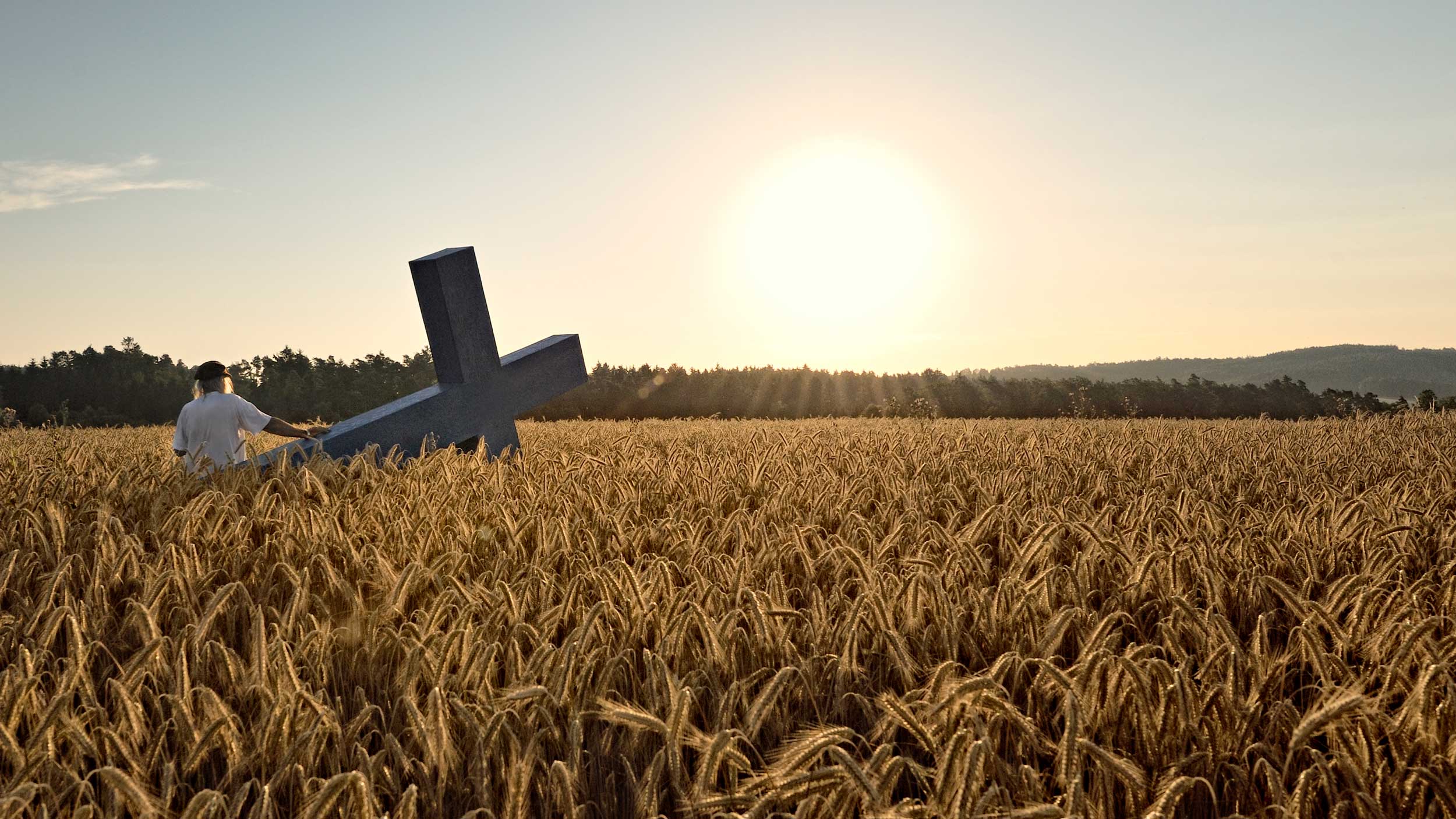 Ostern | ©Stefan Winkelhöfer Ein Mann steht mit Kreuz im Kornfeld