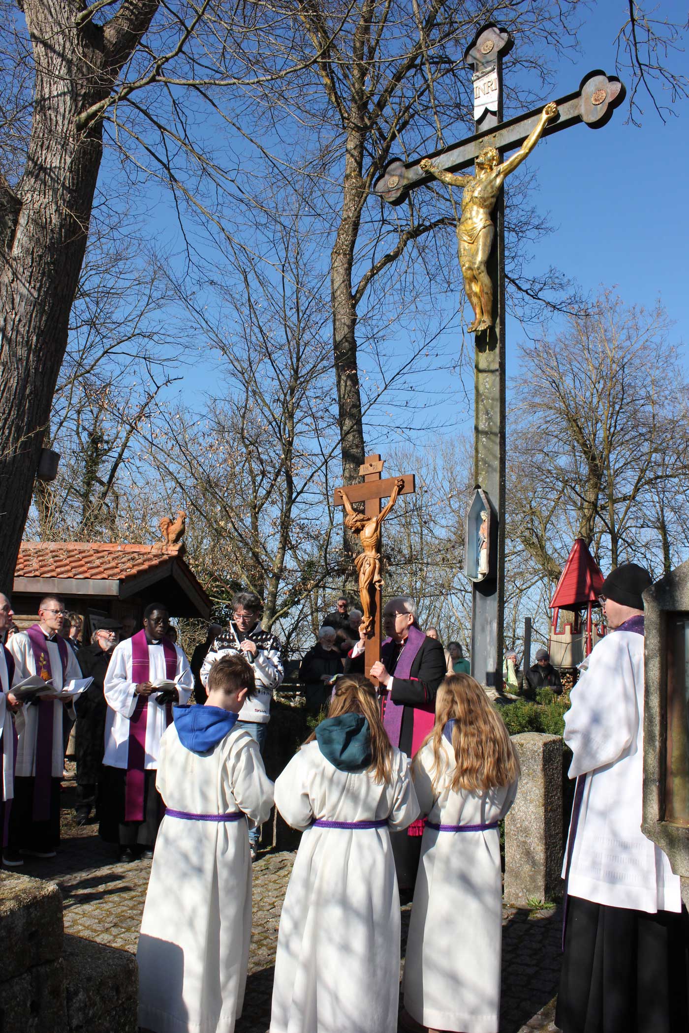 Ministranten mit dem großen Vortragekreuz.