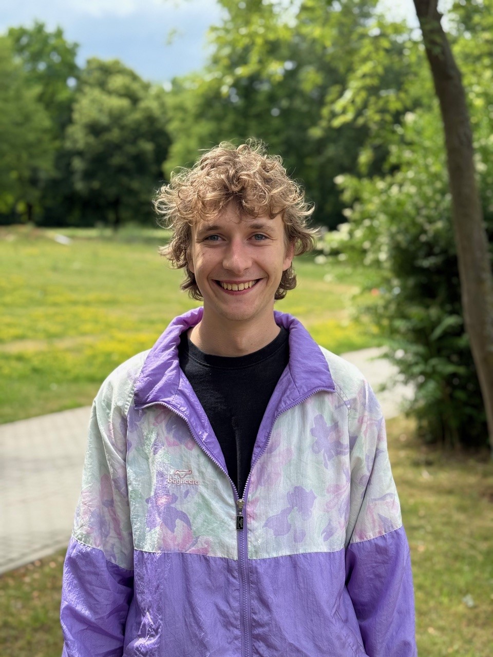Porträt von Simon Hoffmann in einem grünen Park