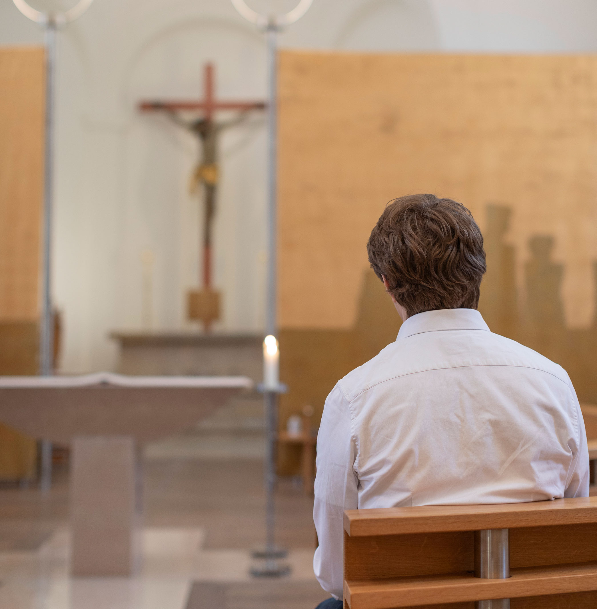 Betender Mann vor einem Kreuz