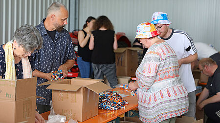 Ehrenamtliche und BJA-Mitarbeiter helfen zusammen um das Pilgermaterial für die Minis zu verpacken.