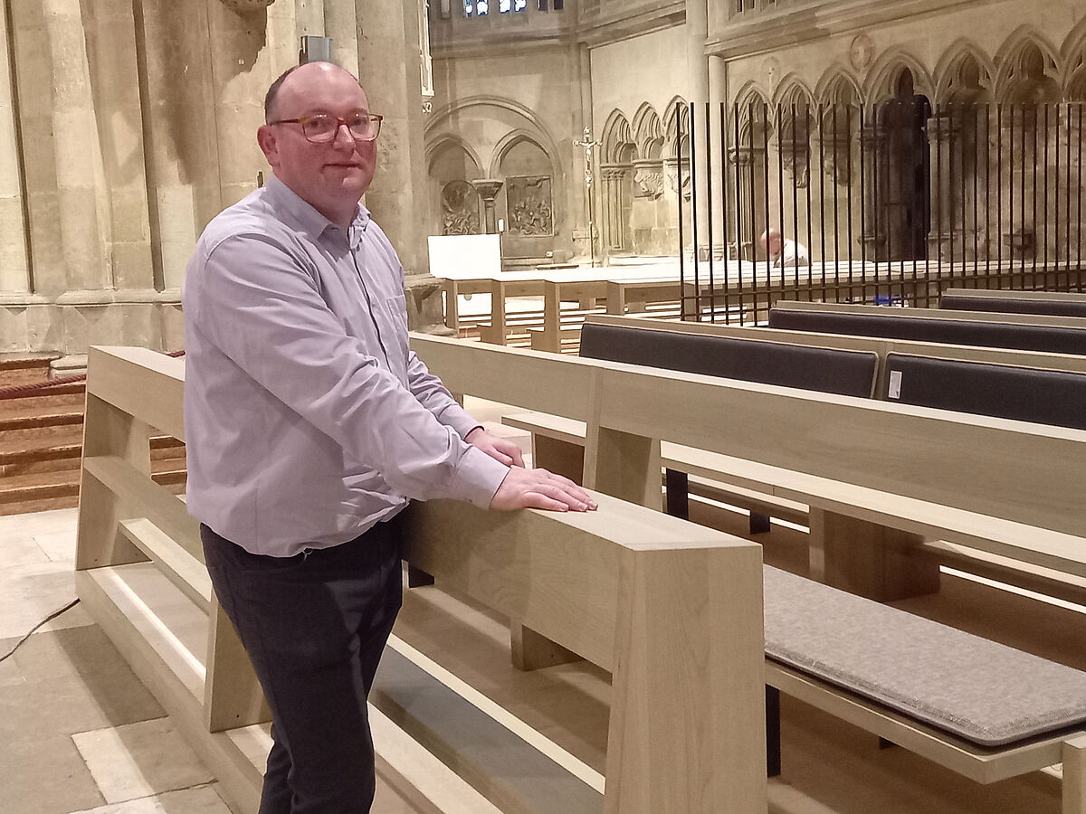 Robert Feigl steht vor dem neuen Gestühl im Regensburger Dom. 