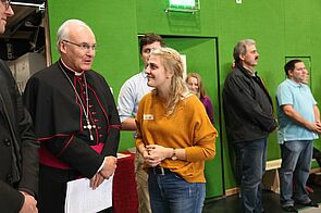 Bischof und junge Frau unterhalten sich