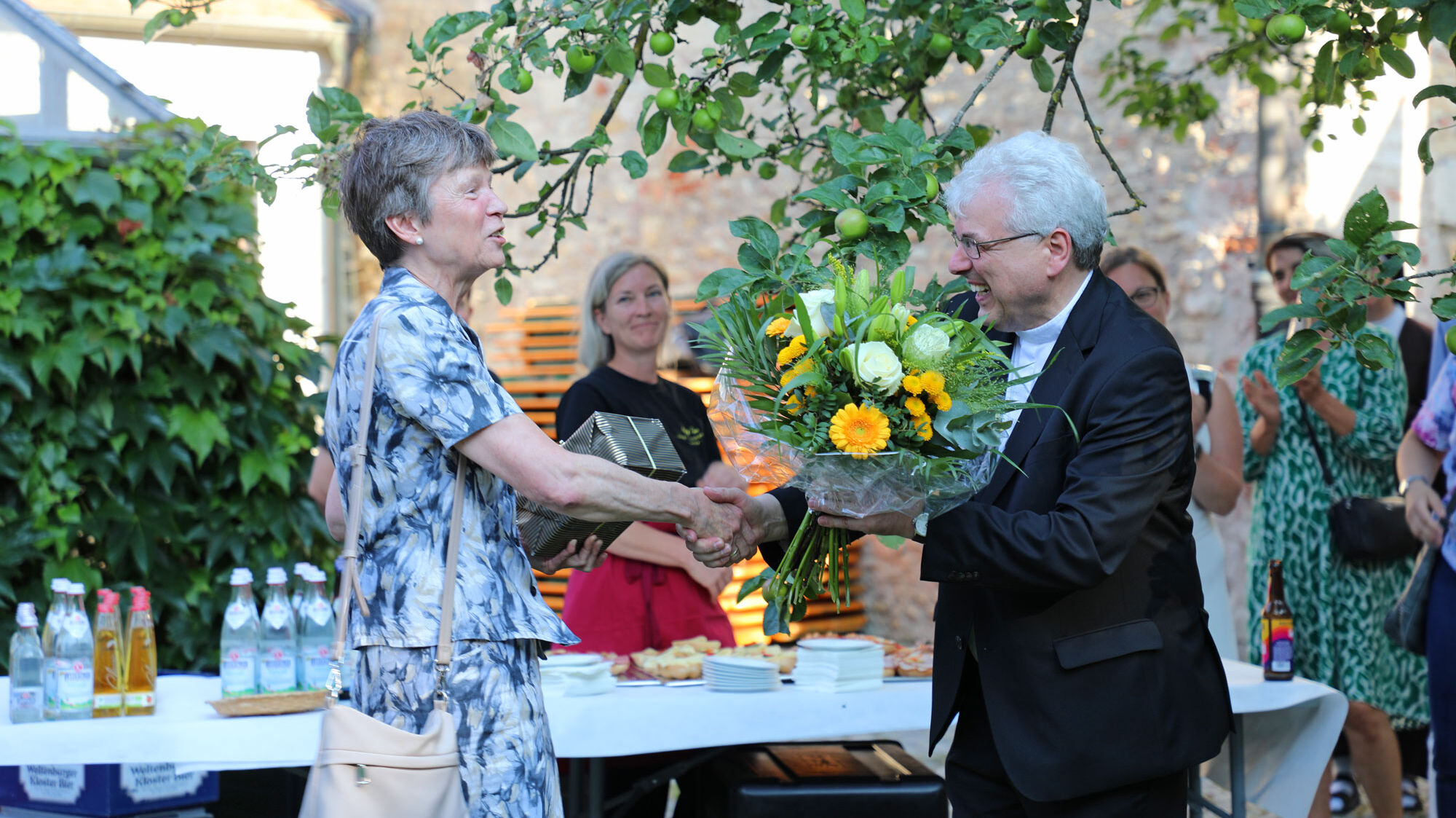 Prof. Dr. Kreiml überreicht seiner Vorgängerin Ordinariatsrätin María Luisa Öfele einen Blumenstrauß