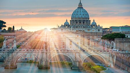 Die Sonne geht hinter dem Petersdom und Tiber unter