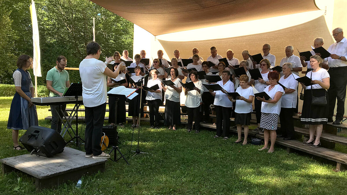 Chor singt, draußen unter einem Baldachin