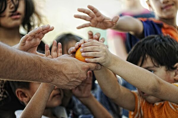 Kinder in Kriegsgebiet greifen nach Orange