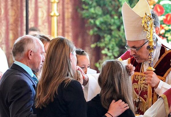Bischof legt Firmling die Hand auf