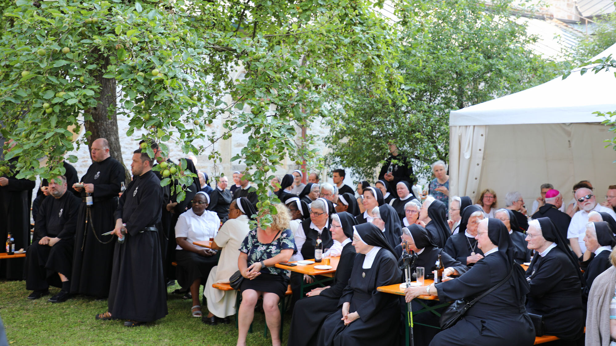 Die Teilnehmer der Heiligen messe begegnen sich im Anschluss im Garten neben der Basilika St. Emmeram