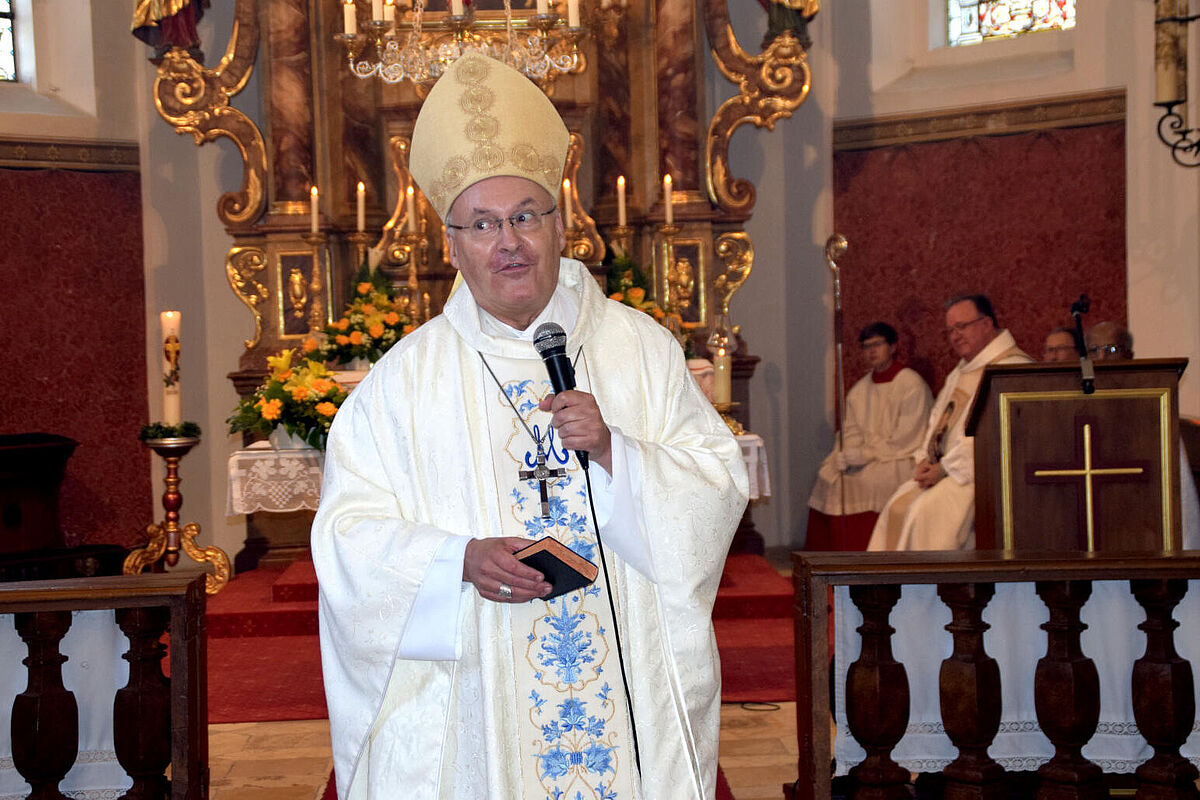 Bischof predigt mit Mikrofon in der Hand