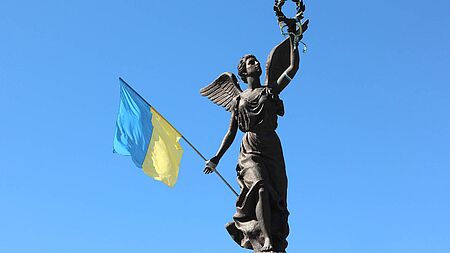 Unabhängiskeitsstatue hält Flagge der Ukraine