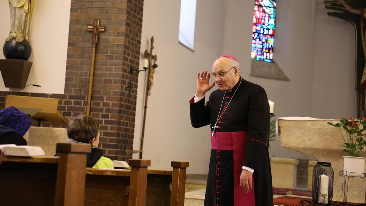 Bischof Voderholzer hört den Kommunionkindern zu