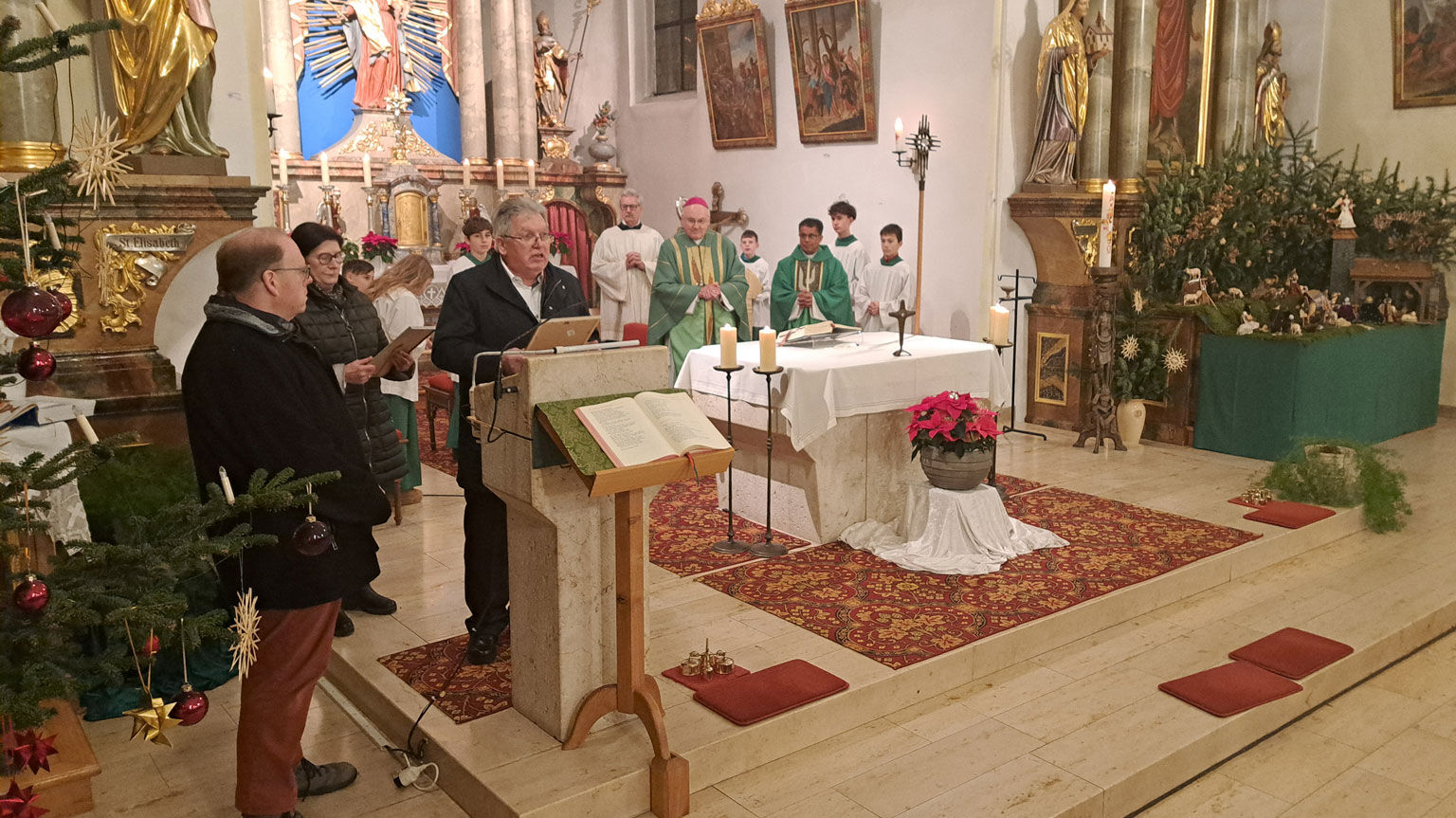 Unter den Augen des Bischofs ehrten Kirchenpfleger Josef Peter (am Ambo) und PGR-Sprecherin Sophie Haimerl (links dahinter) das langjährige Kirchenverwaltungs- und Pfarrgemeinderatsmitglied Christian Zollner (links).