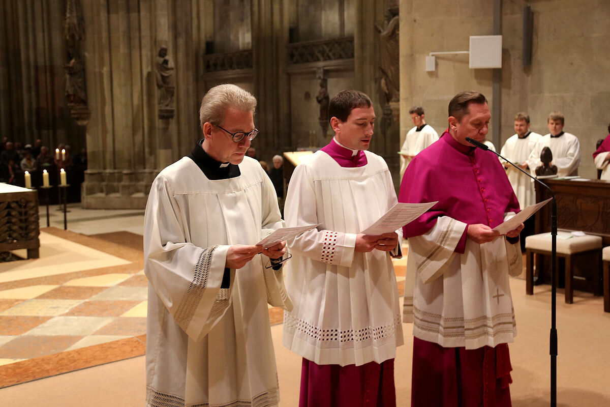 Drei Priester nebeneinander am Altar mit Gebetsbüchern